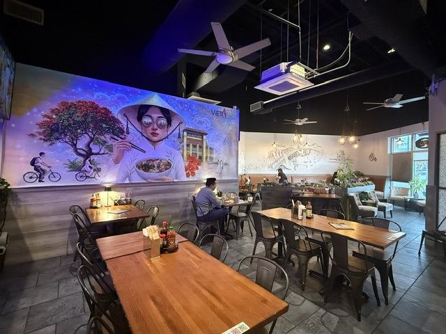 Viet Fire Kitchen dining area with blue-lit Vietnamese mural